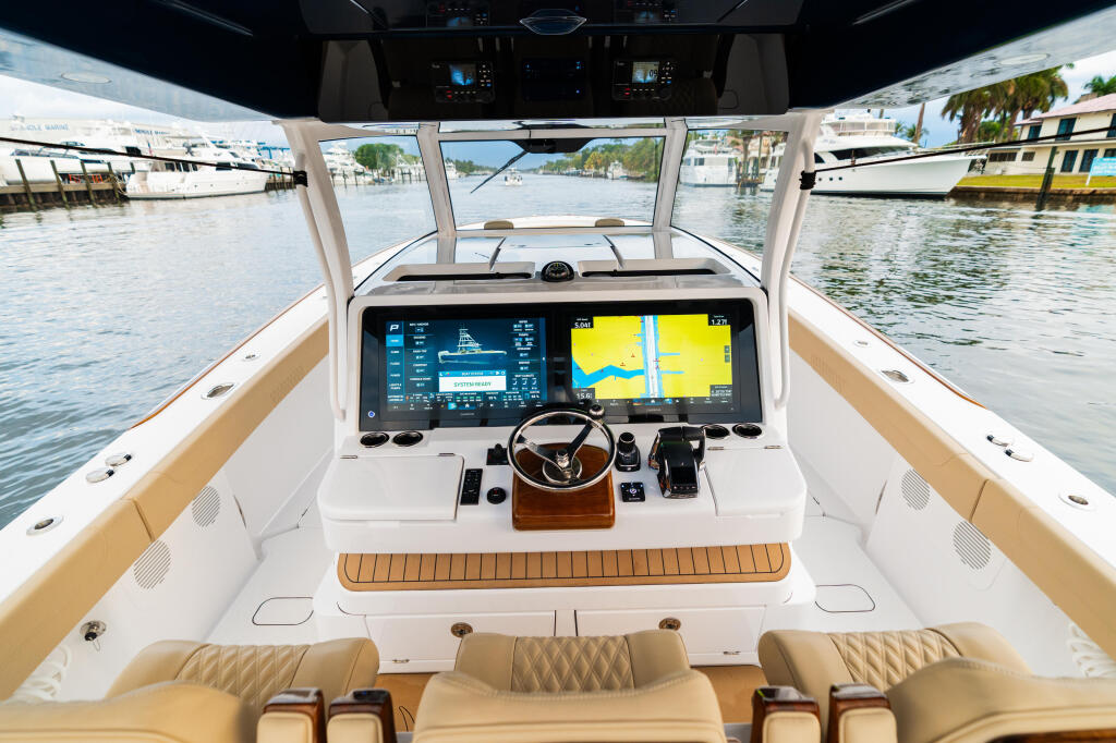 Twin Garmin 9227 multifunction displays at helm with controls and seating in modern boat cabin