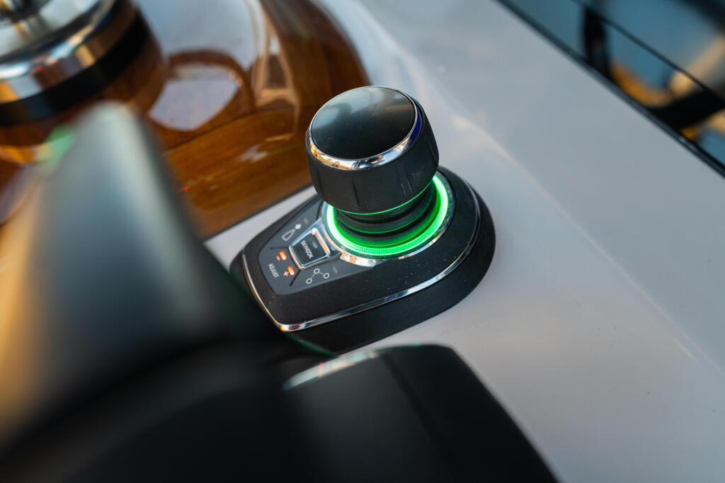 Illuminated joystick control with green ring at boat helm station