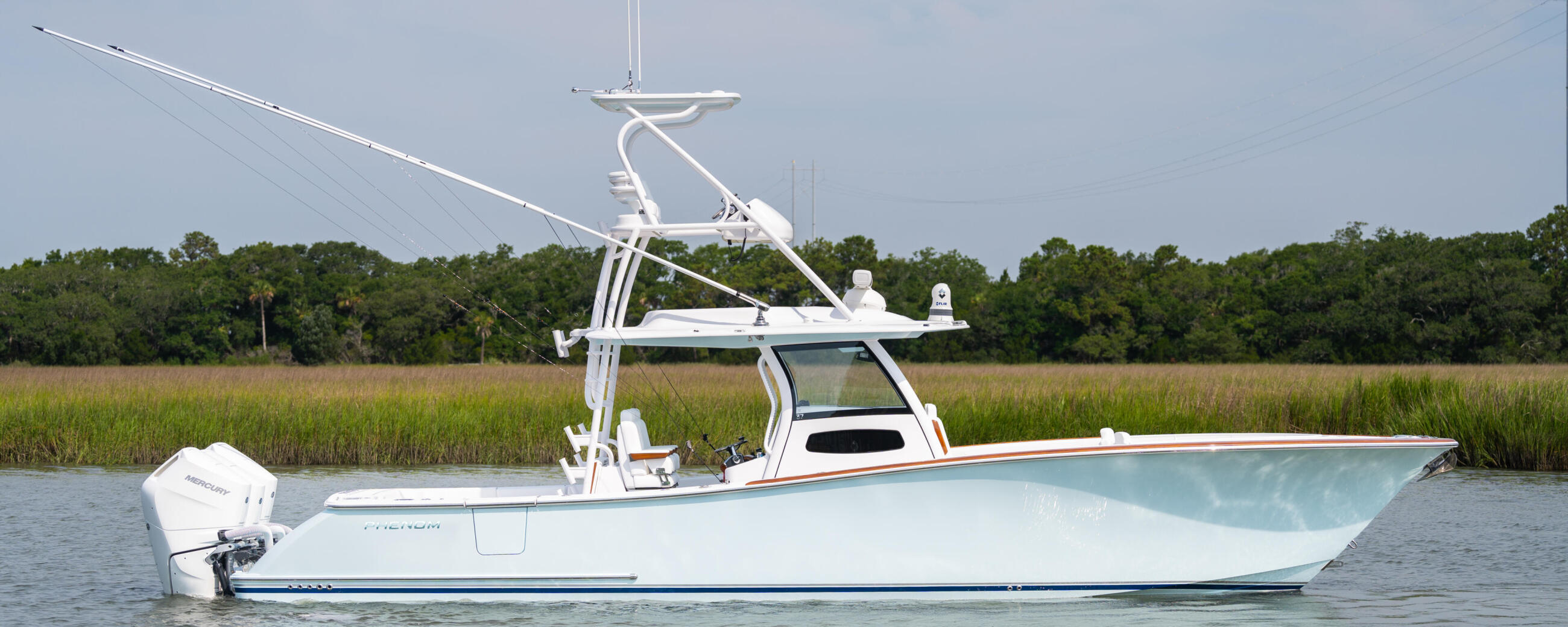White center console boat with tall T-top and electronics mounted in shallow marsh waters
