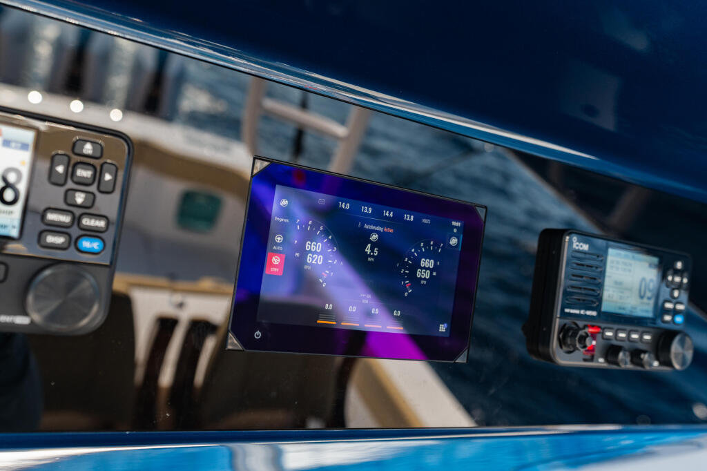 Marine electronics display screen showing vessel diagnostics and navigation data on boat helm