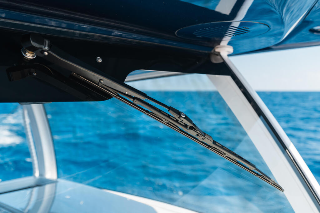 Windshield wiper mechanism on boat windshield with open water visible behind