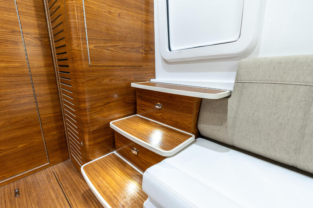 Cabin interior with wood-pattern flooring, white cabinetry, and upholstered seating