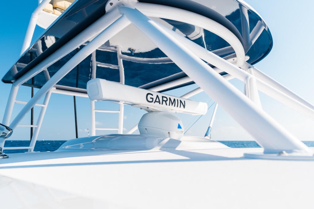 Garmin radar antenna mounted on white hard-top frame of fishing boat with ocean horizon in background